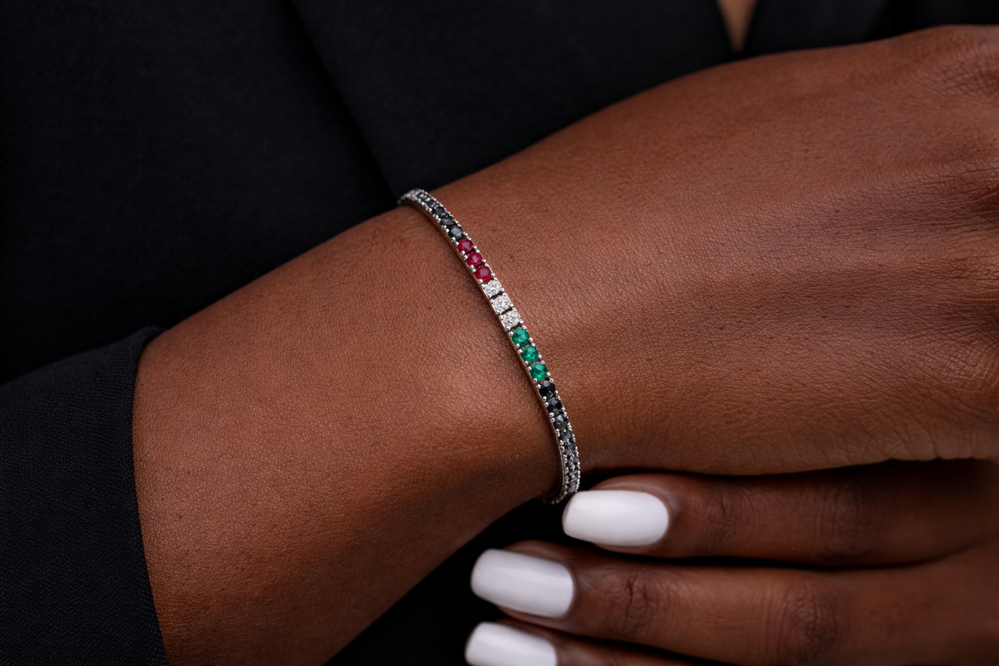 Bracciale tennis con diamanti neri ct 4,55 - diamanti bianchi ct 0,18 - rubini ct 0,24 - smeraldi ct 0,19 in oro bianco 18kt (750)