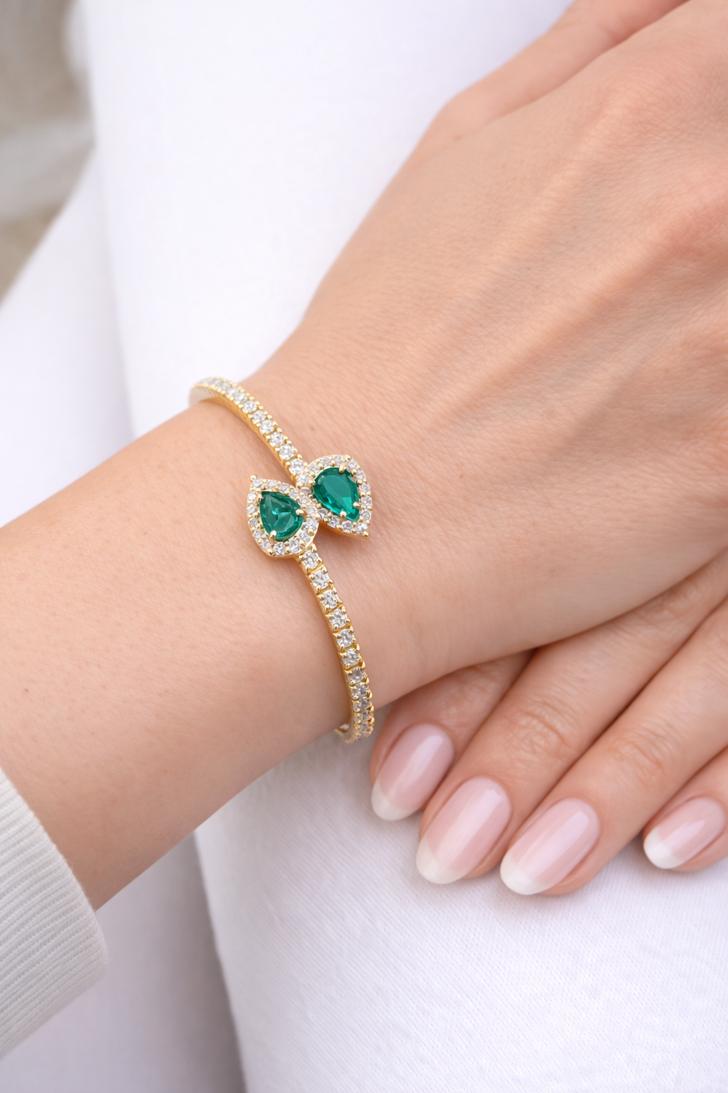 Bracciale tennis elastico contrarié “Astralia” con smeraldi 0,77 ct e diamanti 0,92 ct in oro giallo 18kt (750)